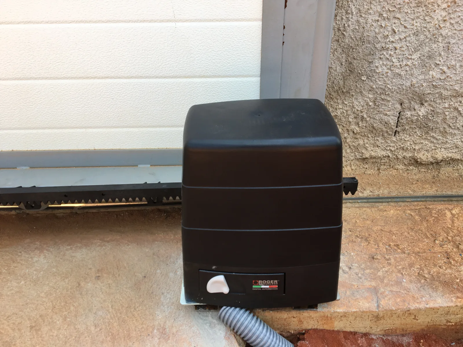 Motor para portão de correr instalado na base do portão, com cremalheira dentada — automatismos Grupo KEFE, Luanda.