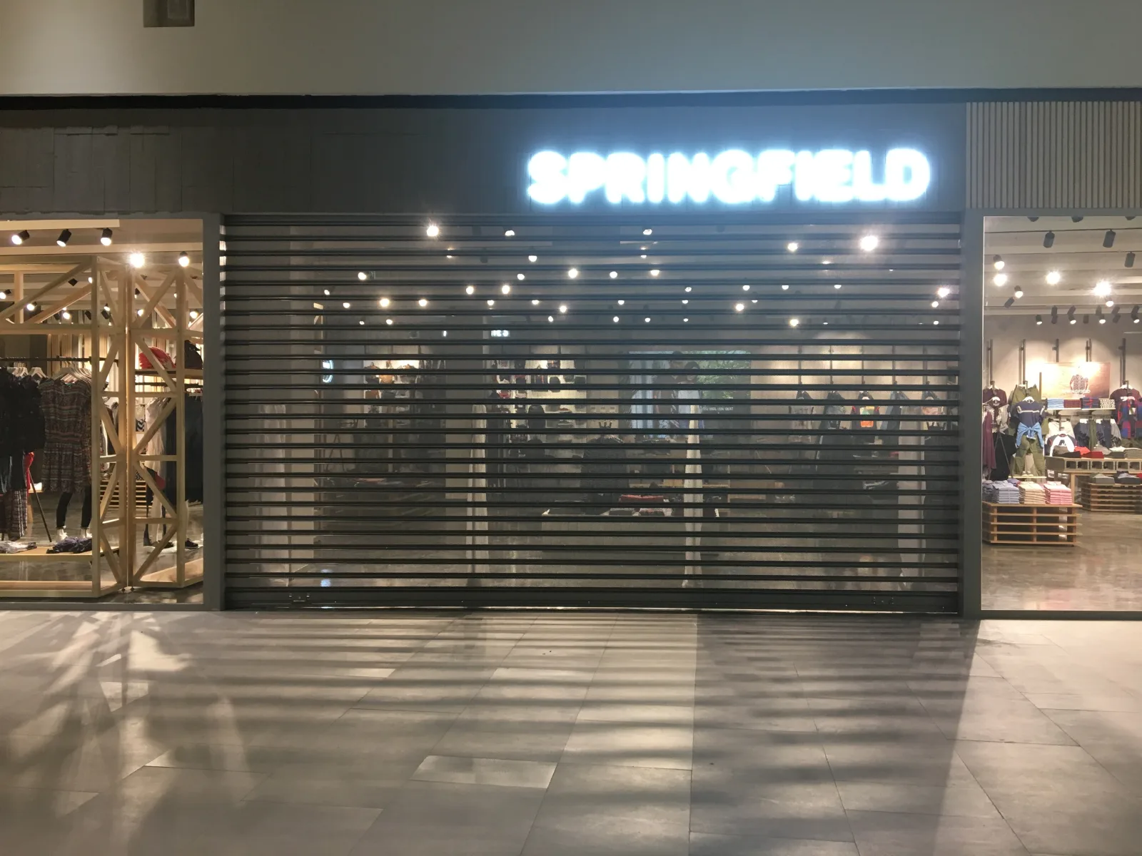 Grade de enrolar micro-perfurada com visibilidade da montra numa loja Springfield — Grupo KEFE, Luanda.