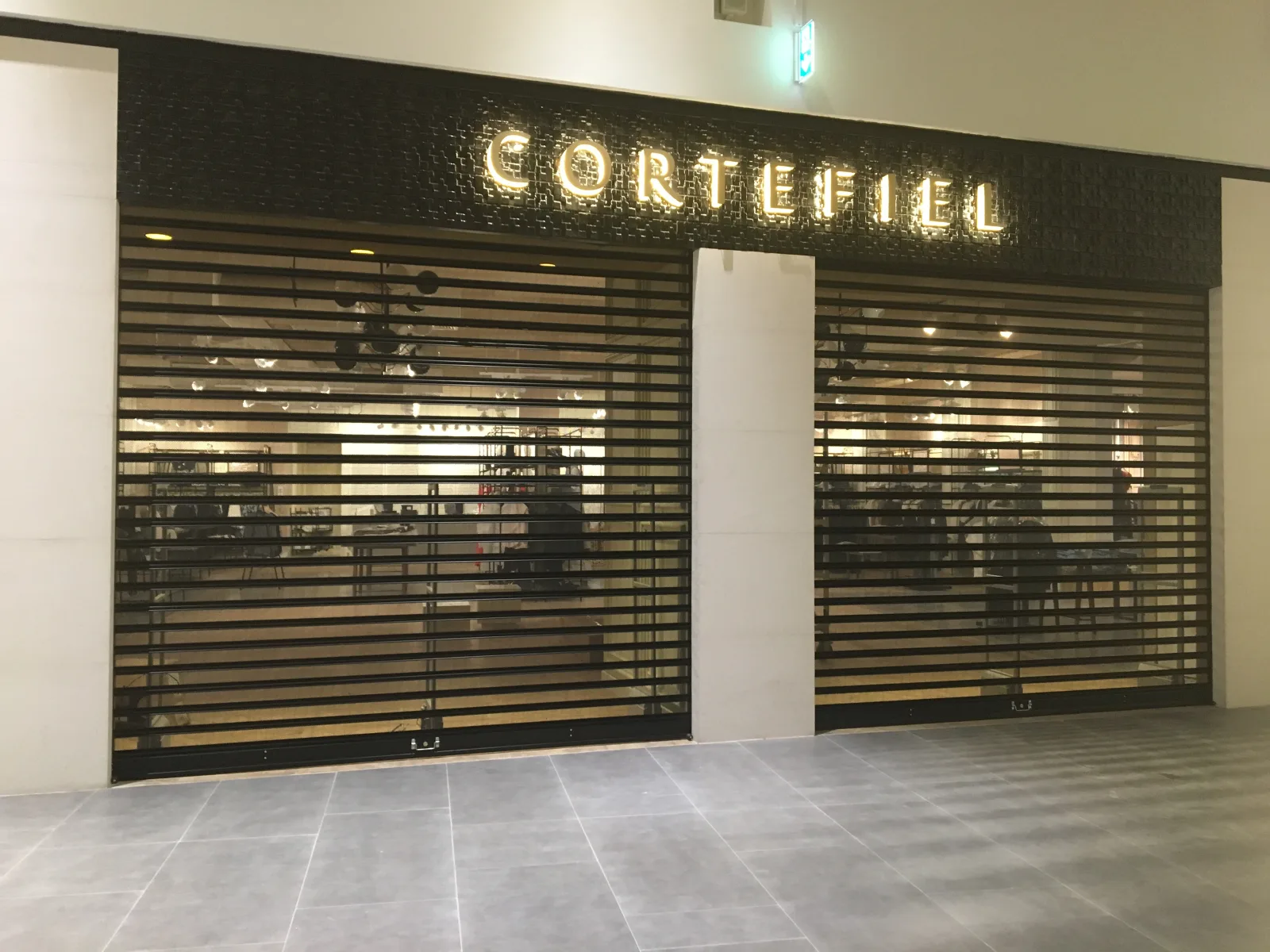 Grade de enrolar micro-perfurada, com visibilidade da montra, numa loja Cortefiel num centro comercial — Grupo KEFE, Luanda.