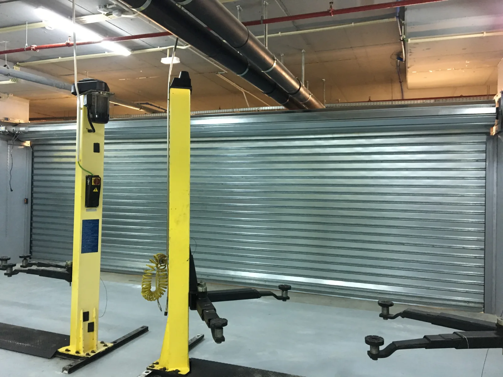 Grade de enrolar cega em aço galvanizado numa oficina auto — Grupo KEFE, Luanda.
