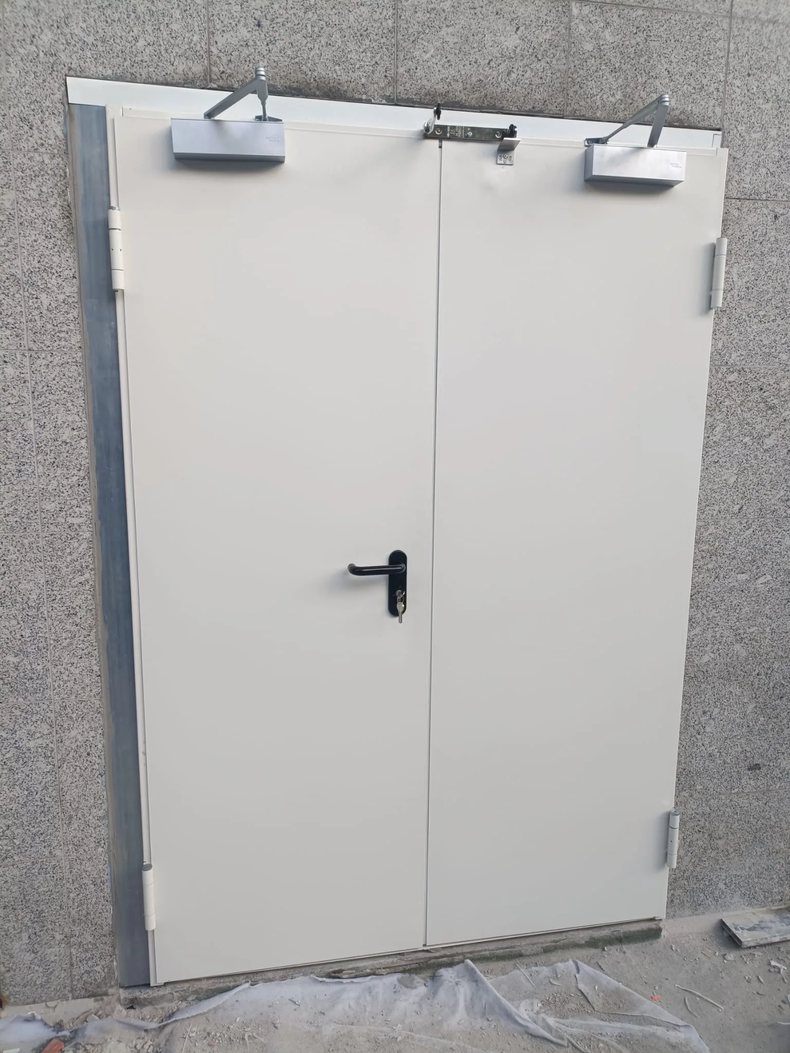 Porta corta-fogo branca de duas folhas com molas de fecho automático — Grupo KEFE, Luanda.