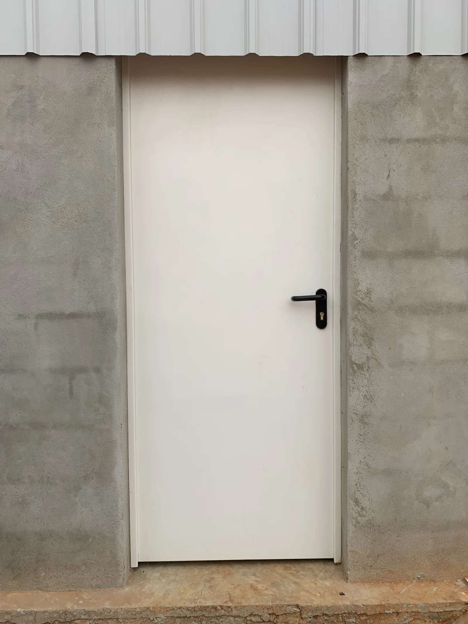 Porta corta-fogo/multiuso branca de uma folha numa parede de blocos — Grupo KEFE, Luanda.