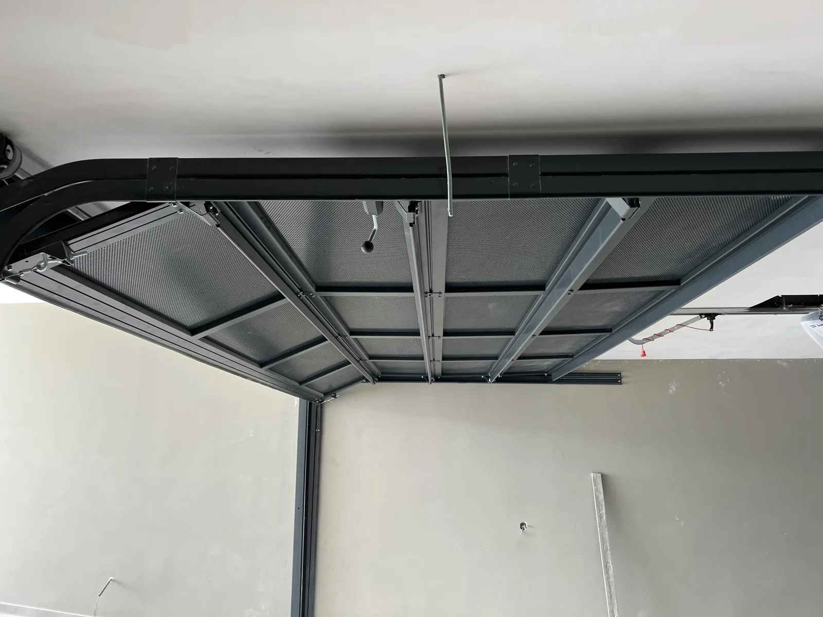 Portão seccionado aberto, recolhido nas calhas horizontais junto ao teto da garagem