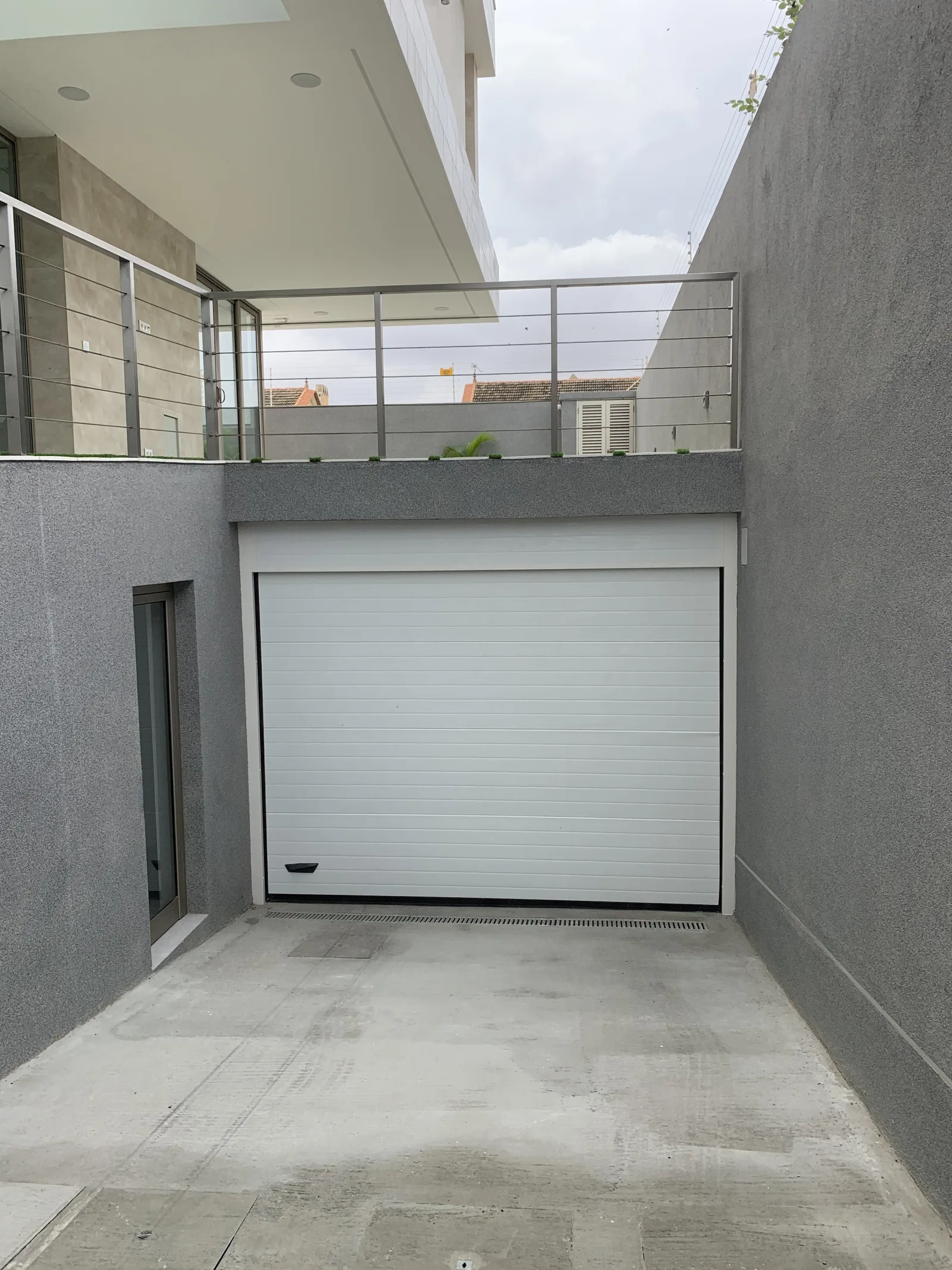 Portão seccionado branco na garagem em cave de uma moradia
