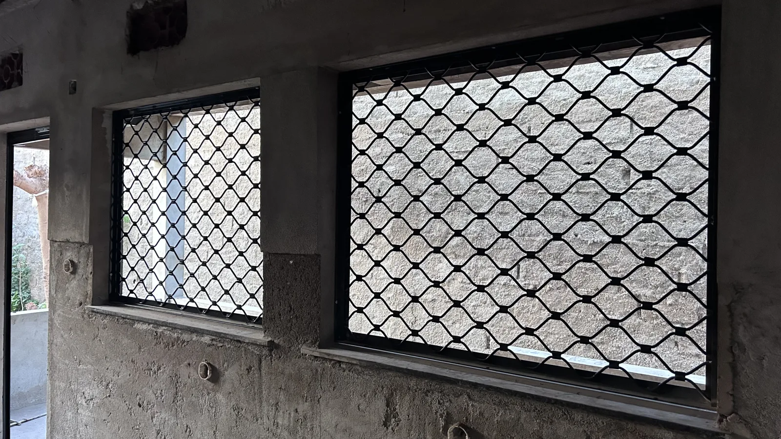 Gradeamento de segurança em malha losangular a proteger duas janelas — Grupo KEFE, Luanda.