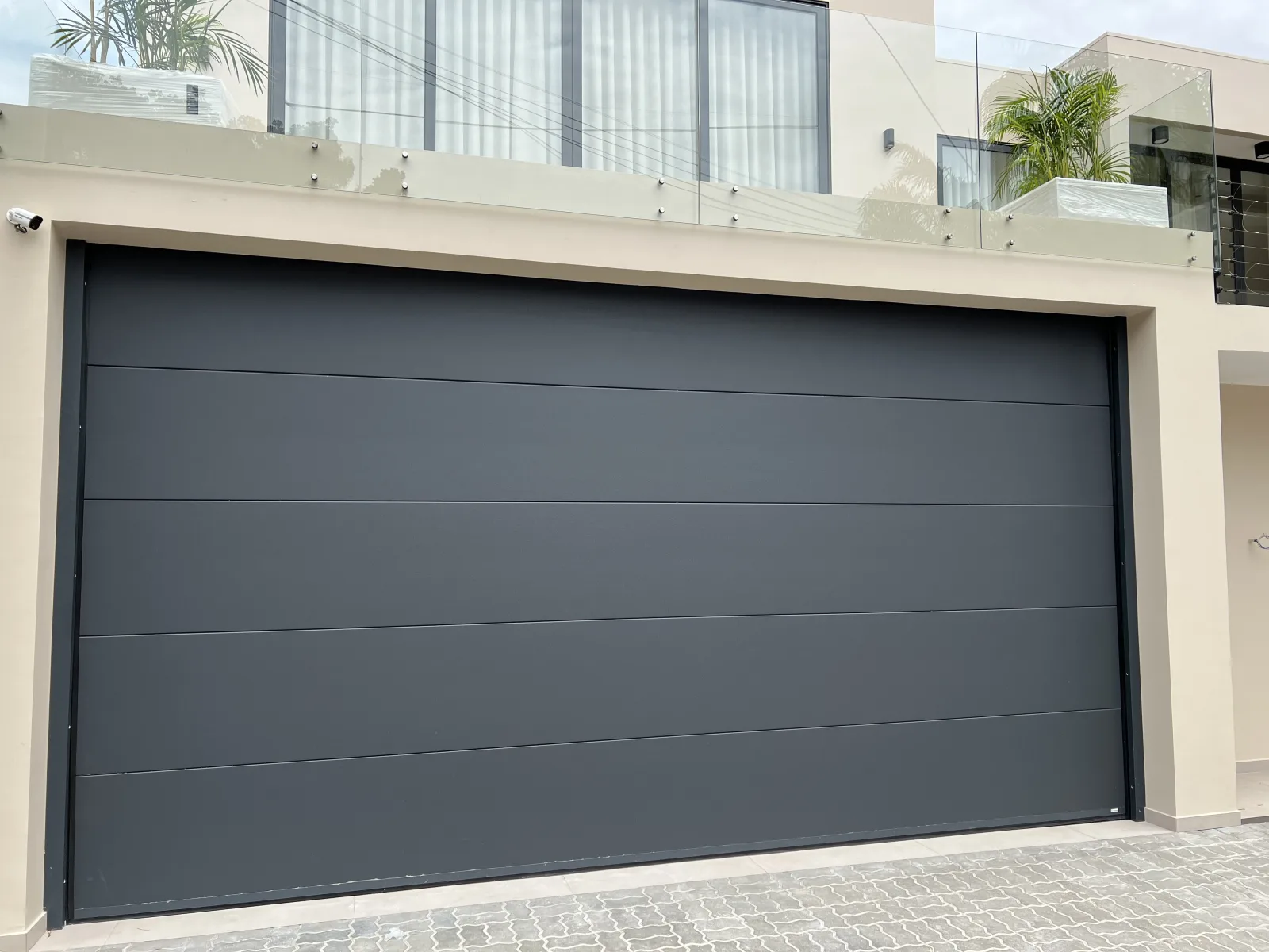 Portão seccionado de painéis lisos em cinzento antracite na garagem de uma moradia