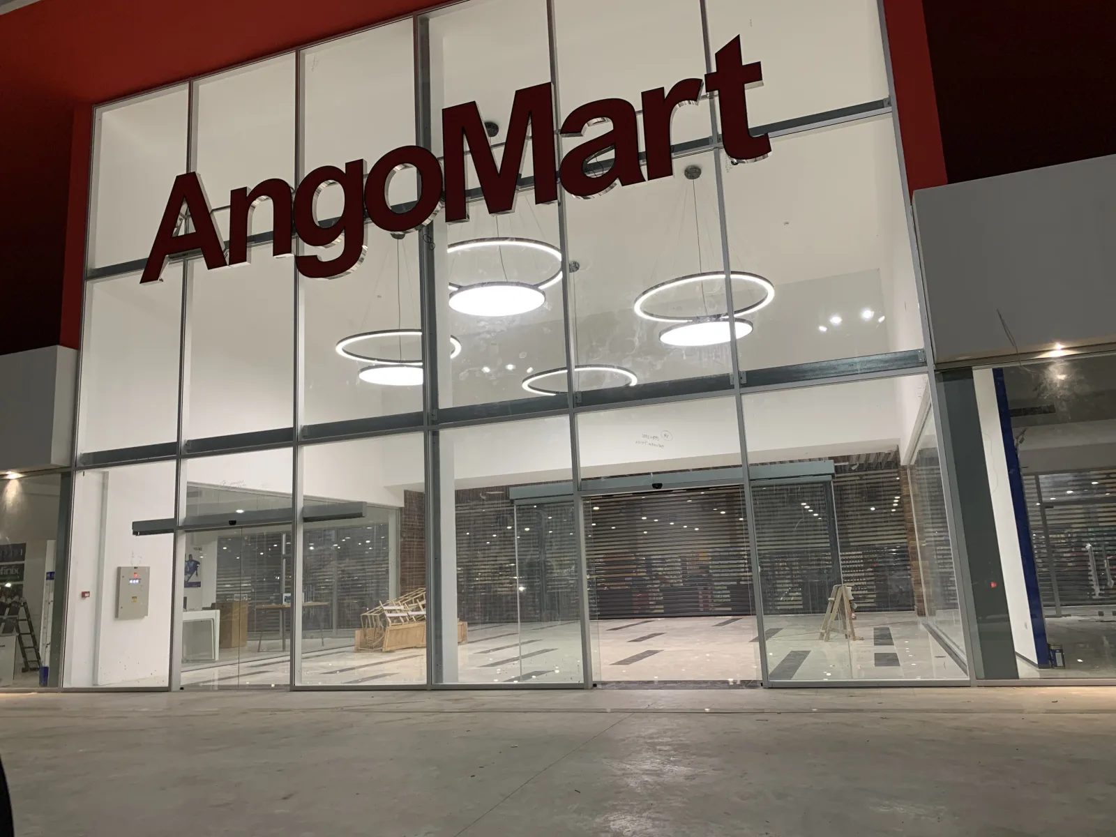 Fachada envidraçada e portas automáticas de vidro na entrada da loja AngoMart — Grupo KEFE, Luanda.